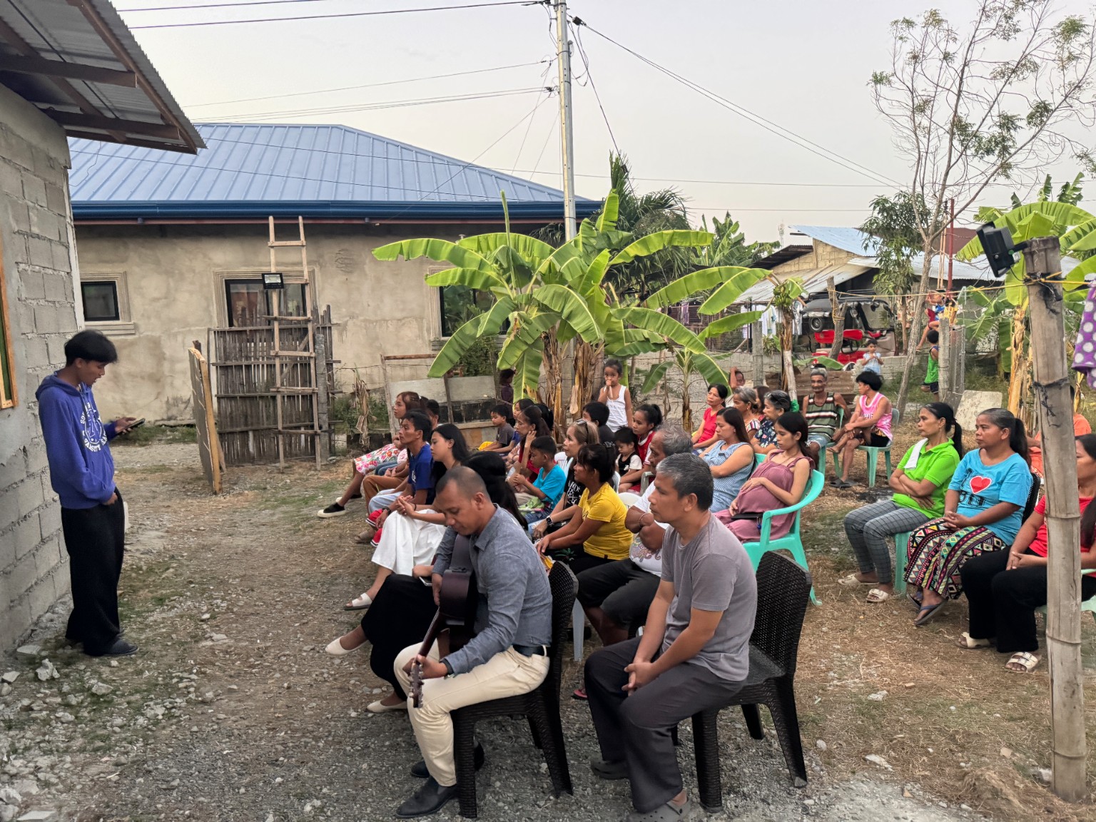 Community members seated together during a daytime outdoor ministry gathering