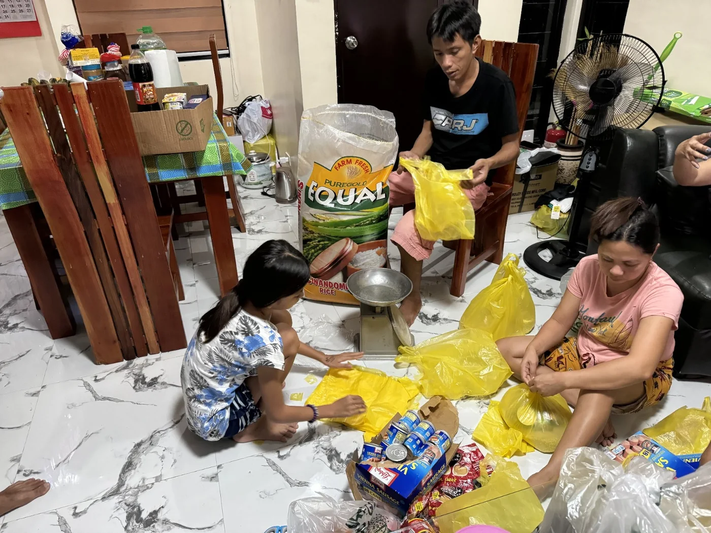 Volunteers measuring rice and packing food supplies for families