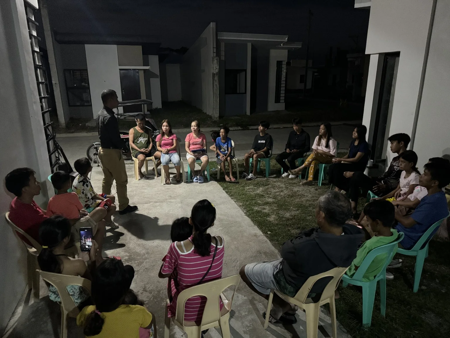 A ministry leader speaking to families seated in a community gathering